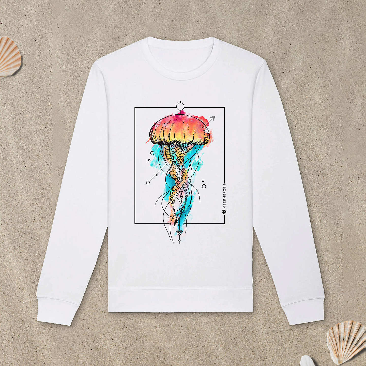 Weißes Sweatshirt mit Qualle-Motiv mit Aquarell-Farben liegt im Sand.
