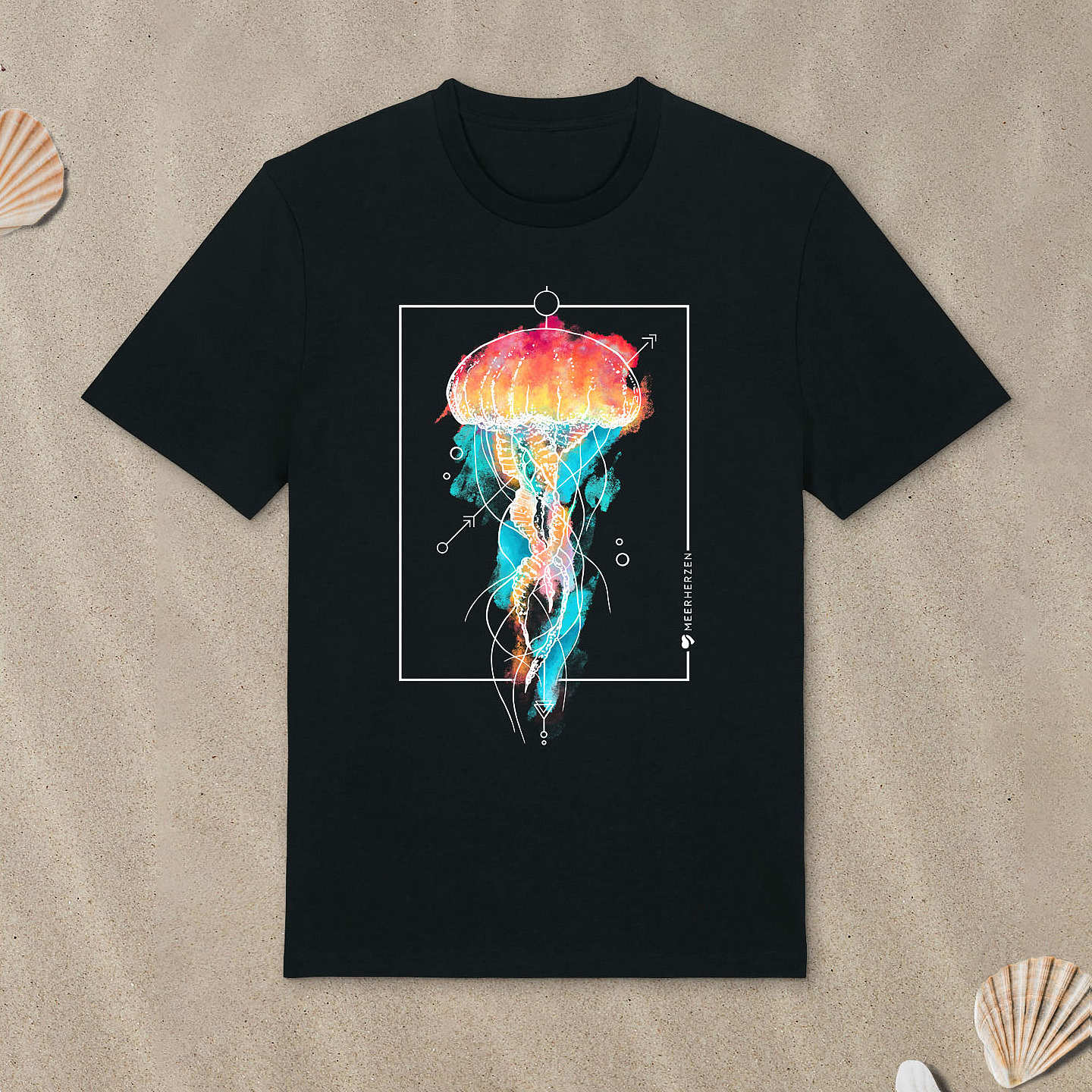 Schwarzes T-Shirt mit Qualle-Motiv mit Aquarell-Farben liegt im Sand.