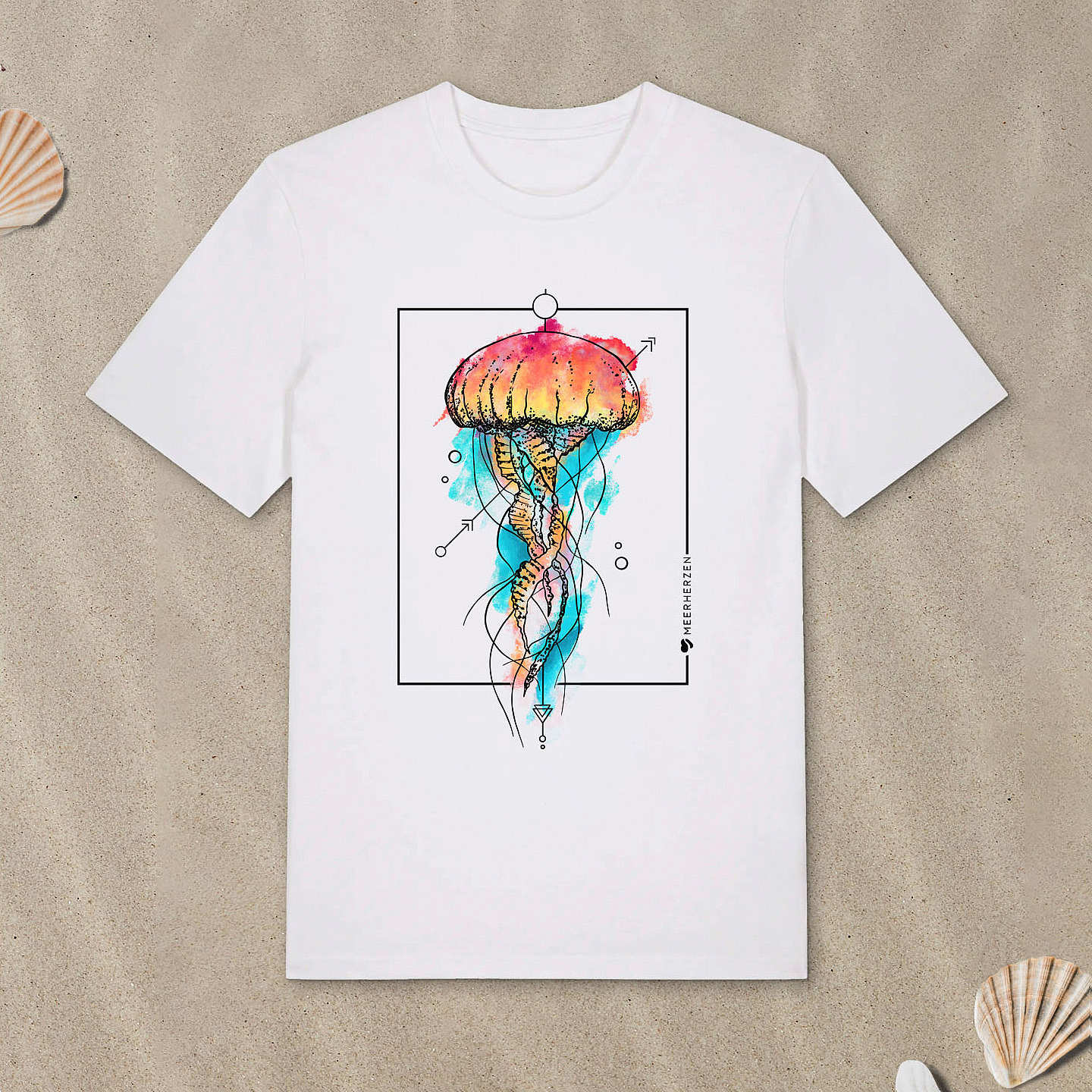 Weißes T-Shirt mit Qualle-Motiv mit Aquarell-Farben liegt im Sand.