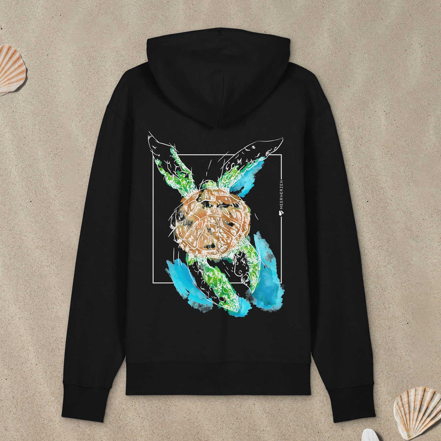 Schwarzer Hoodie Zipper mit Meeresschildkröte-Motiv mit Astrologie-Elementen liegt im Sand.