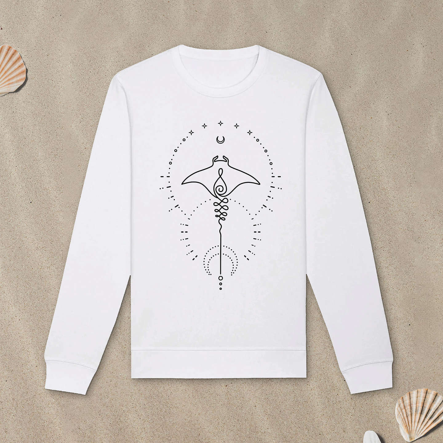 Weißes Sweatshirt mit Manta-Motiv mit Astrologie-Elementen liegt im Sand.