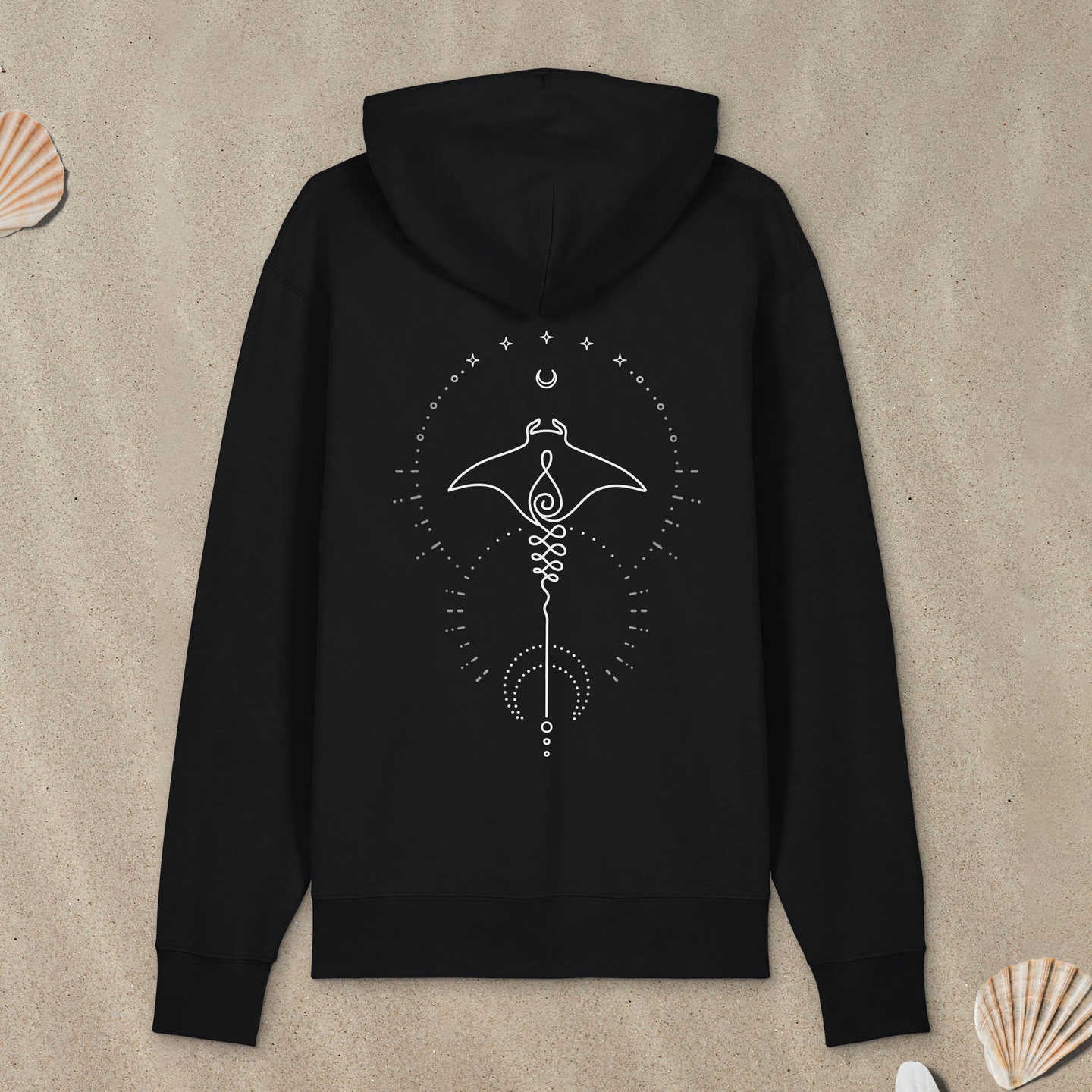 Schwarzer Hoodie Zipper mit Manta-Motiv mit Astrologie-Elementen liegt im Sand.