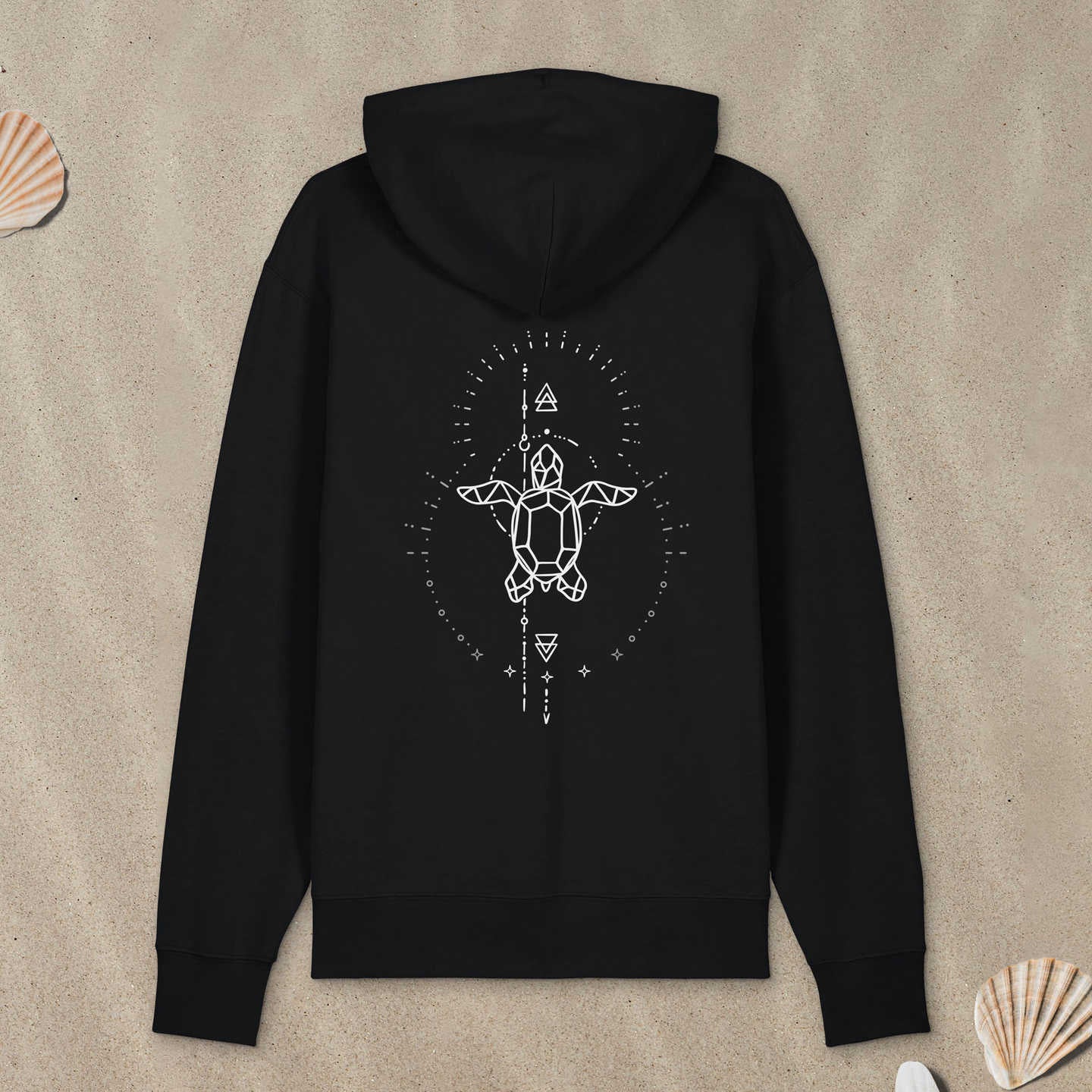 Schwarzer Hoodie Zipper mit Meeresschildkröte-Motiv mit Astrologie-Elementen liegt im Sand.