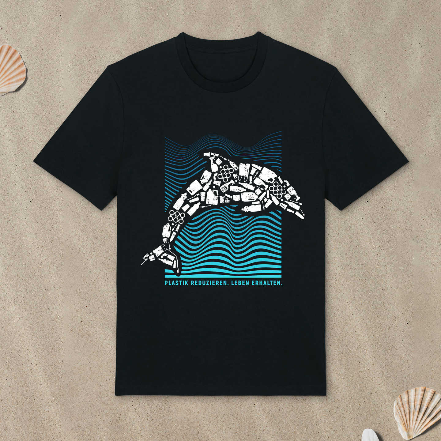 Schwarzes T-Shirt mit Delfin-Motiv liegt im Sand.