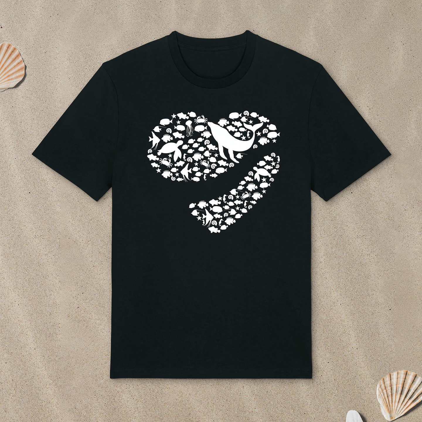 Schwarzes T-Shirt mit Meerestiere-Motiv in Herzform liegt im Sand.