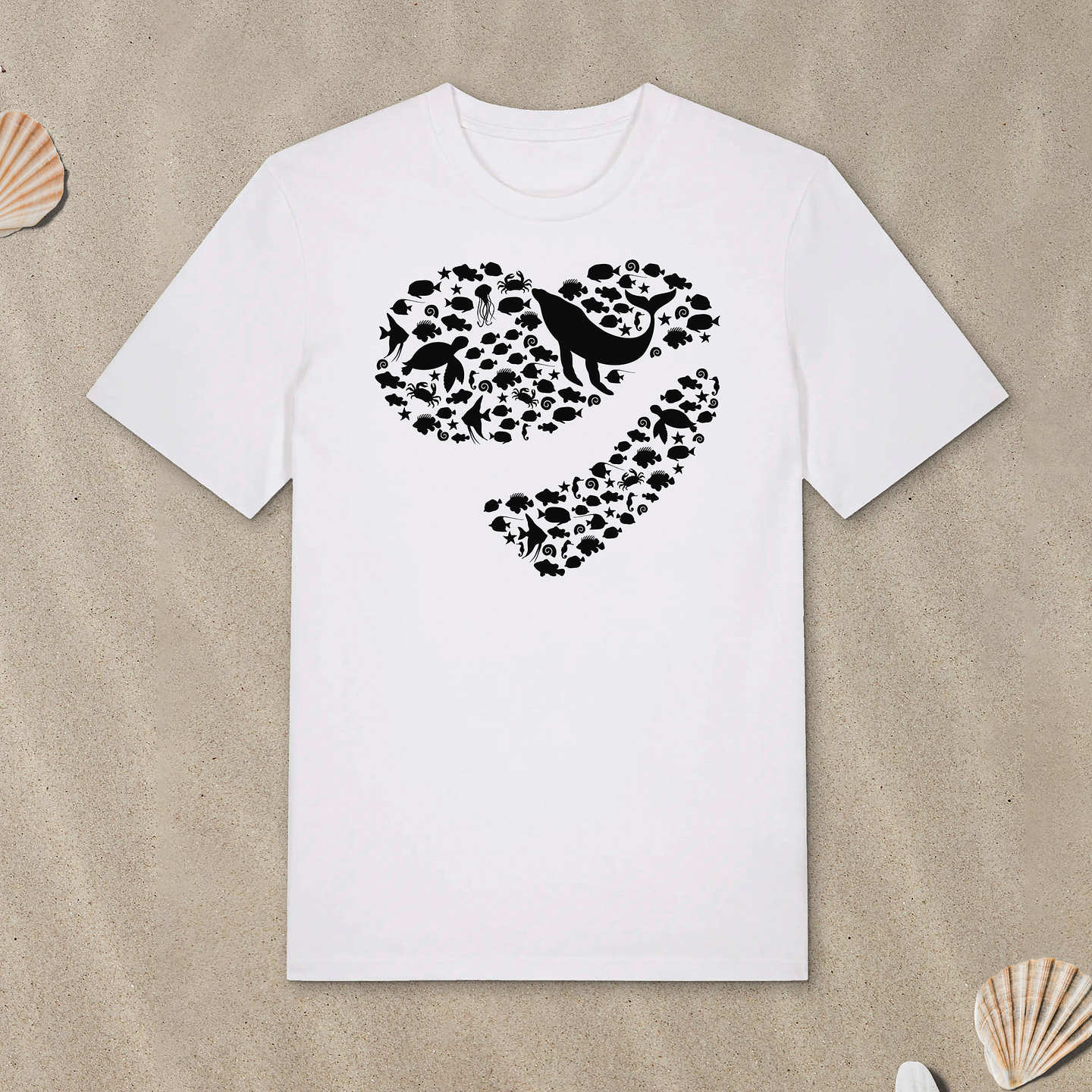 Weißes T-Shirt mit Meerestiere-Motiv in Herzform liegt im Sand.