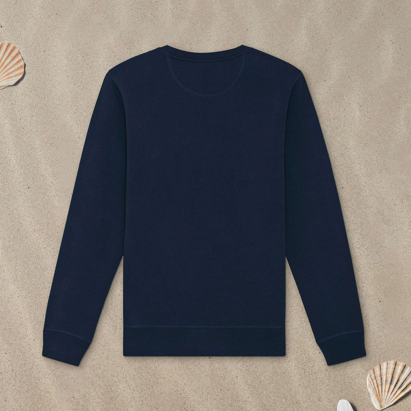 Marineblaues Sweatshirt liegt mit der Rückseite nach oben im Sand.