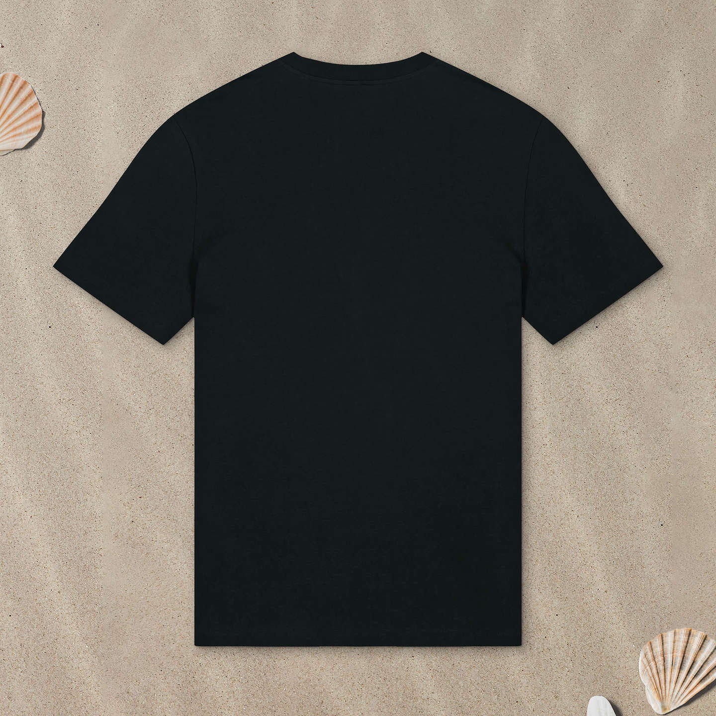 Schwarzes T-Shirt liegt mit der Rückseite nach oben im Sand.