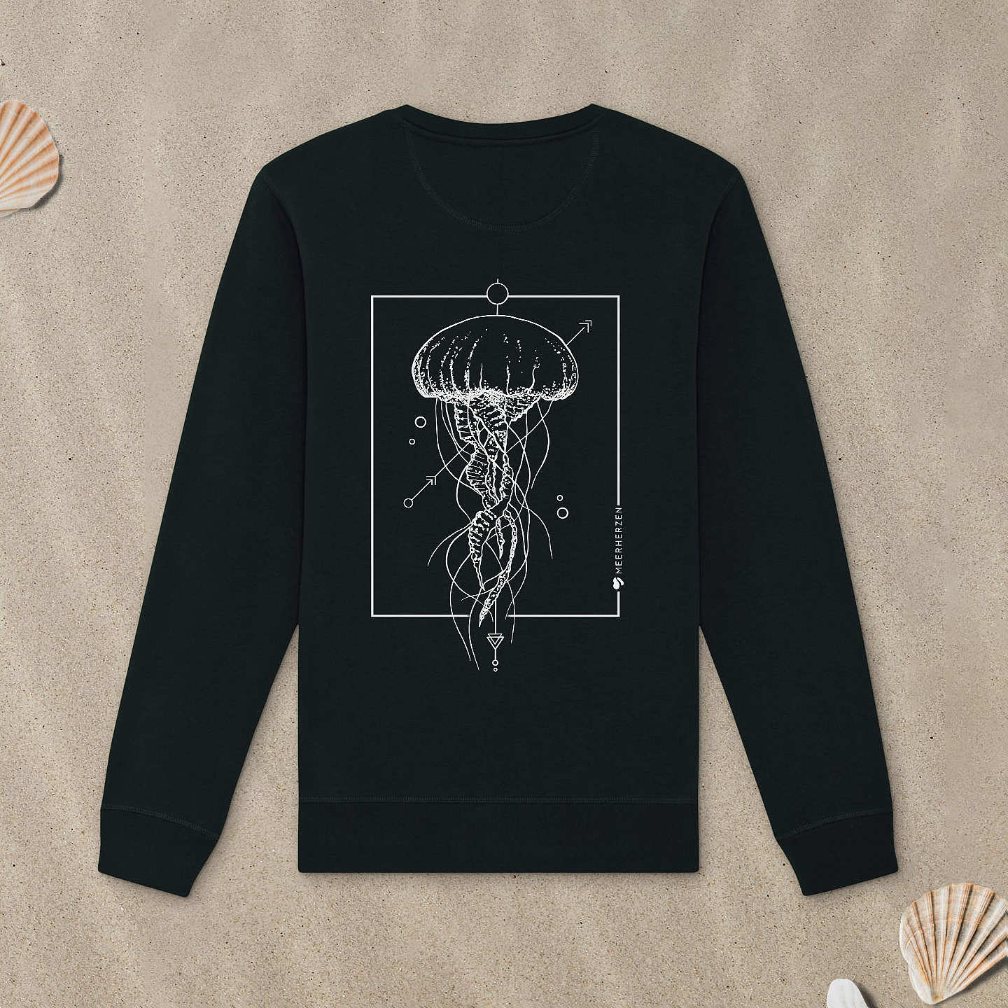 Schwarzes Sweatshirt mit Qualle-Motiv liegt im Sand.