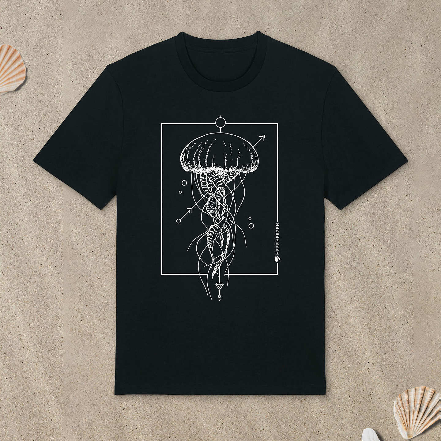 Schwarzes T-Shirt mit Qualle-Motiv liegt im Sand.