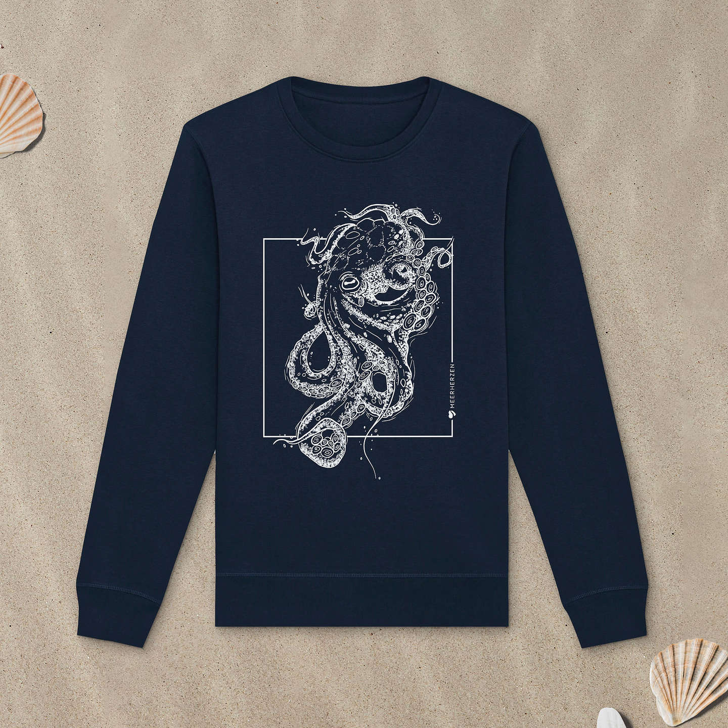 Marineblaues Sweatshirt mit Tintenfisch-Motiv liegt im Sand.