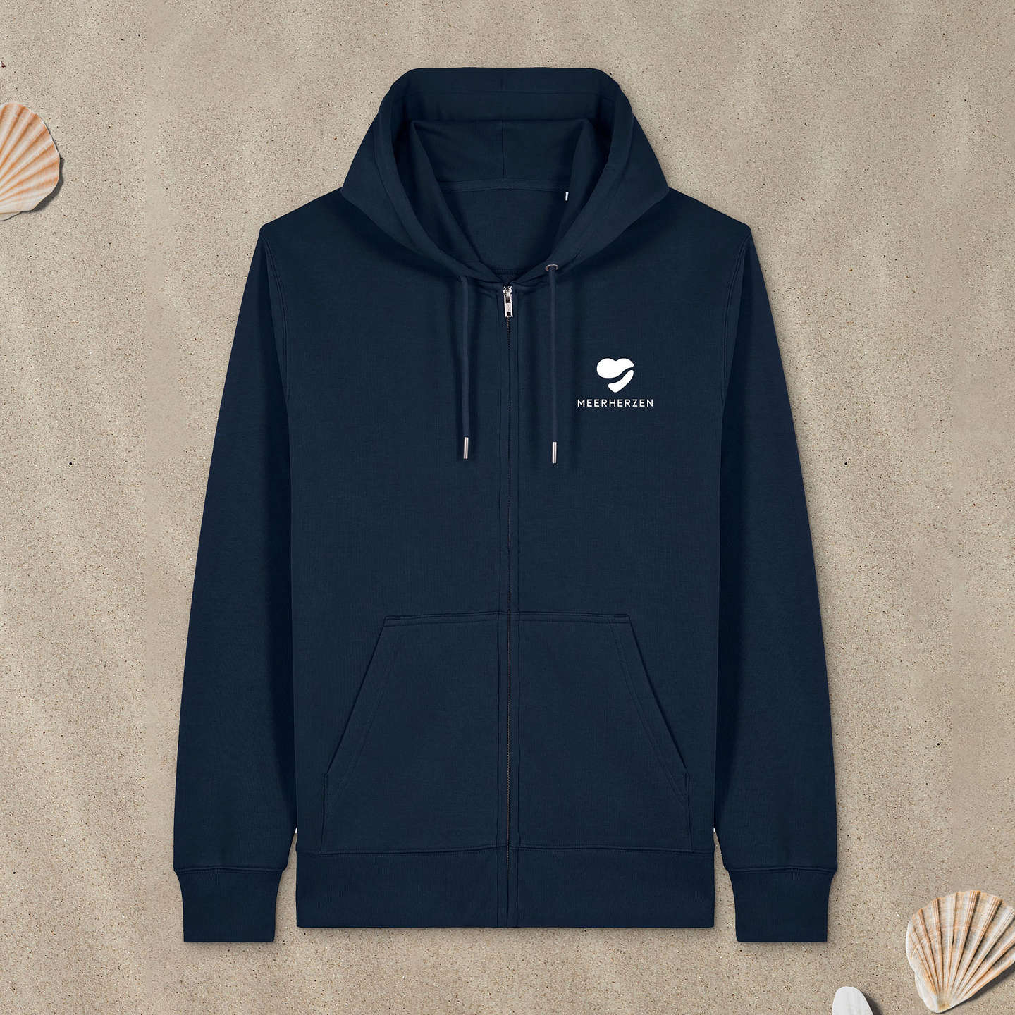 Marineblauer Hoodie Zipper mit Herz-Logo auf der Brust liegt im Sand.