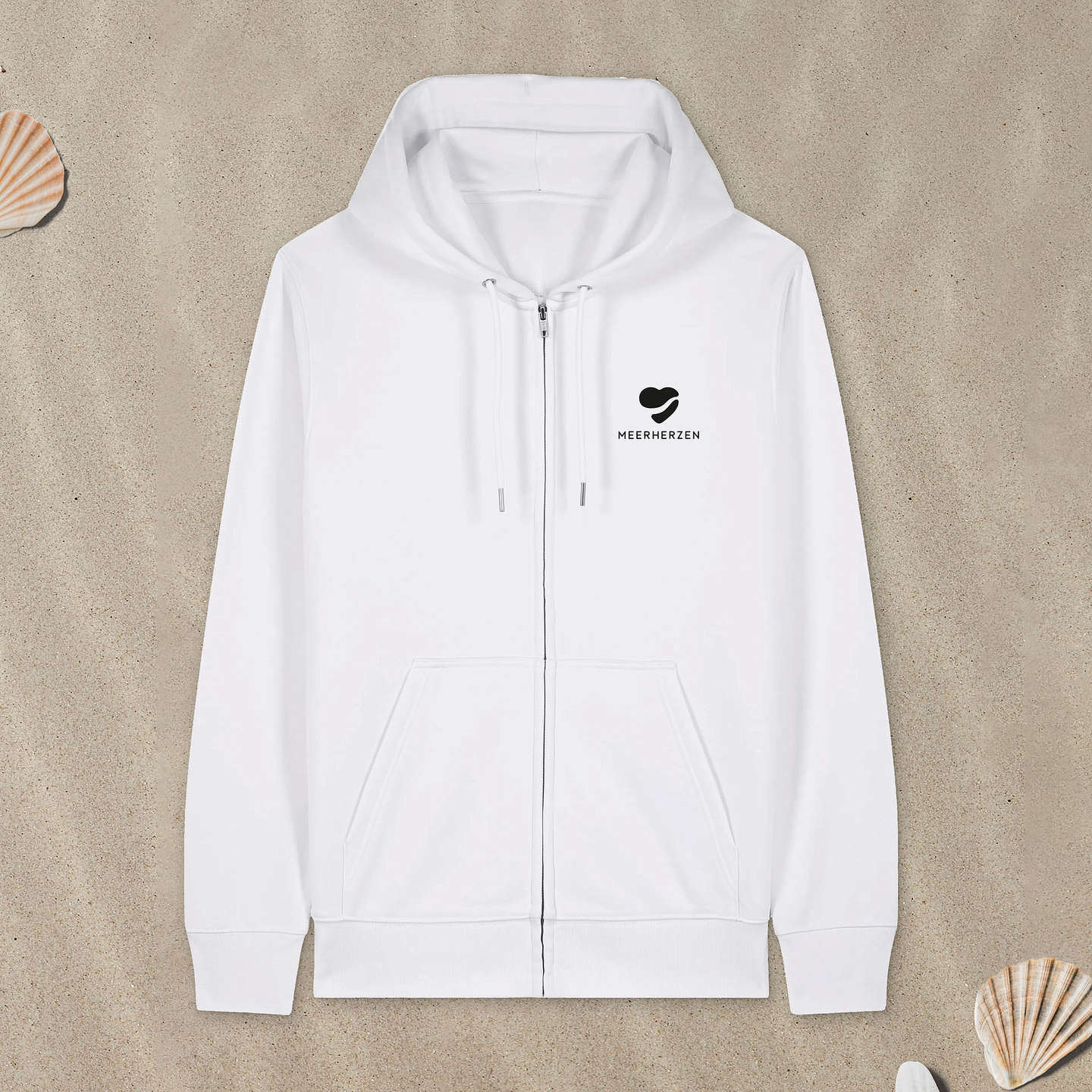 Weißer Hoodie Zipper mit Herz-Logo auf der Brust liegt im Sand.