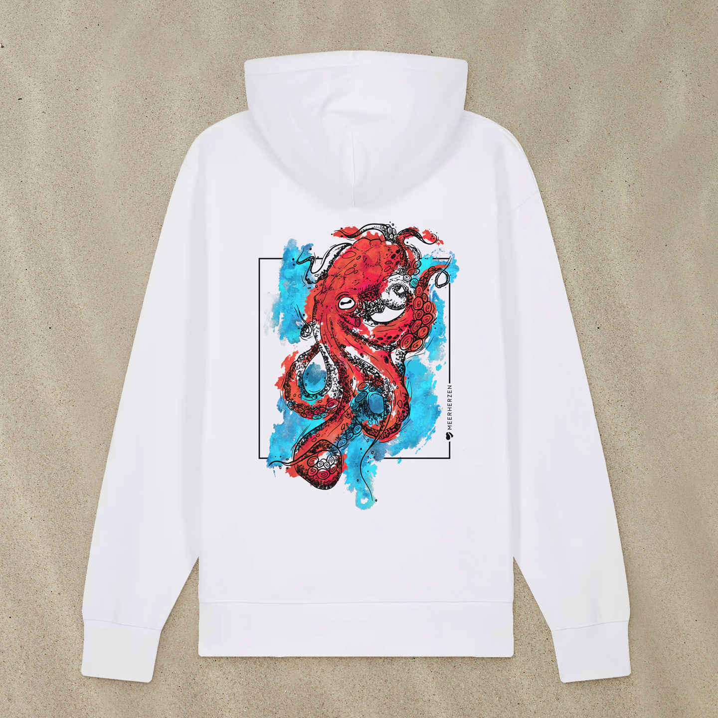 Weißer Hoodie mit Tintenfisch-Motiv mit bunten Aquarell-Farben liegt im Sand.