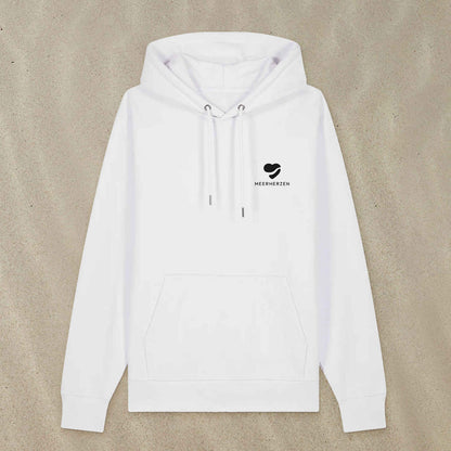 Weißer Hoodie mit Herz-Logo auf der Brust liegt im Sand.