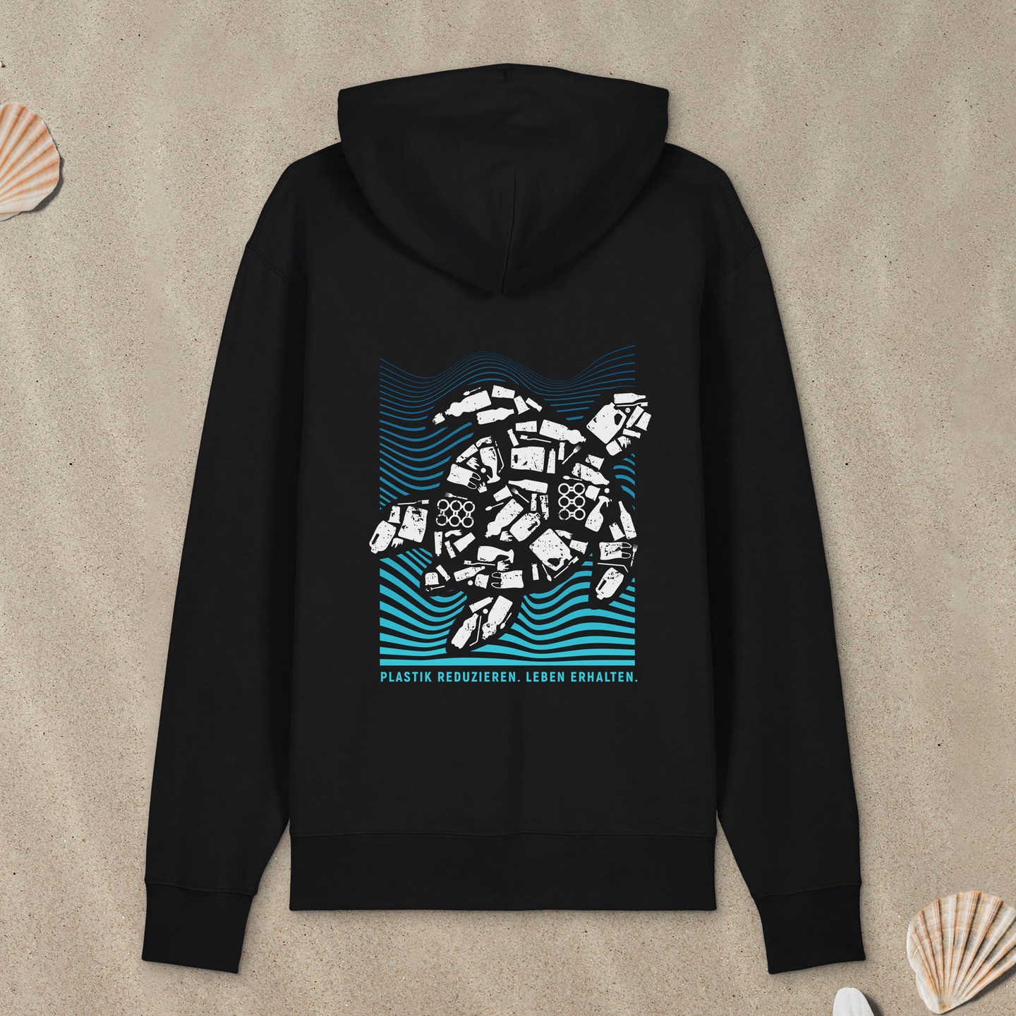 Schwarzer Hoodie mit Meeresschildkröte-Motiv liegt im Sand.