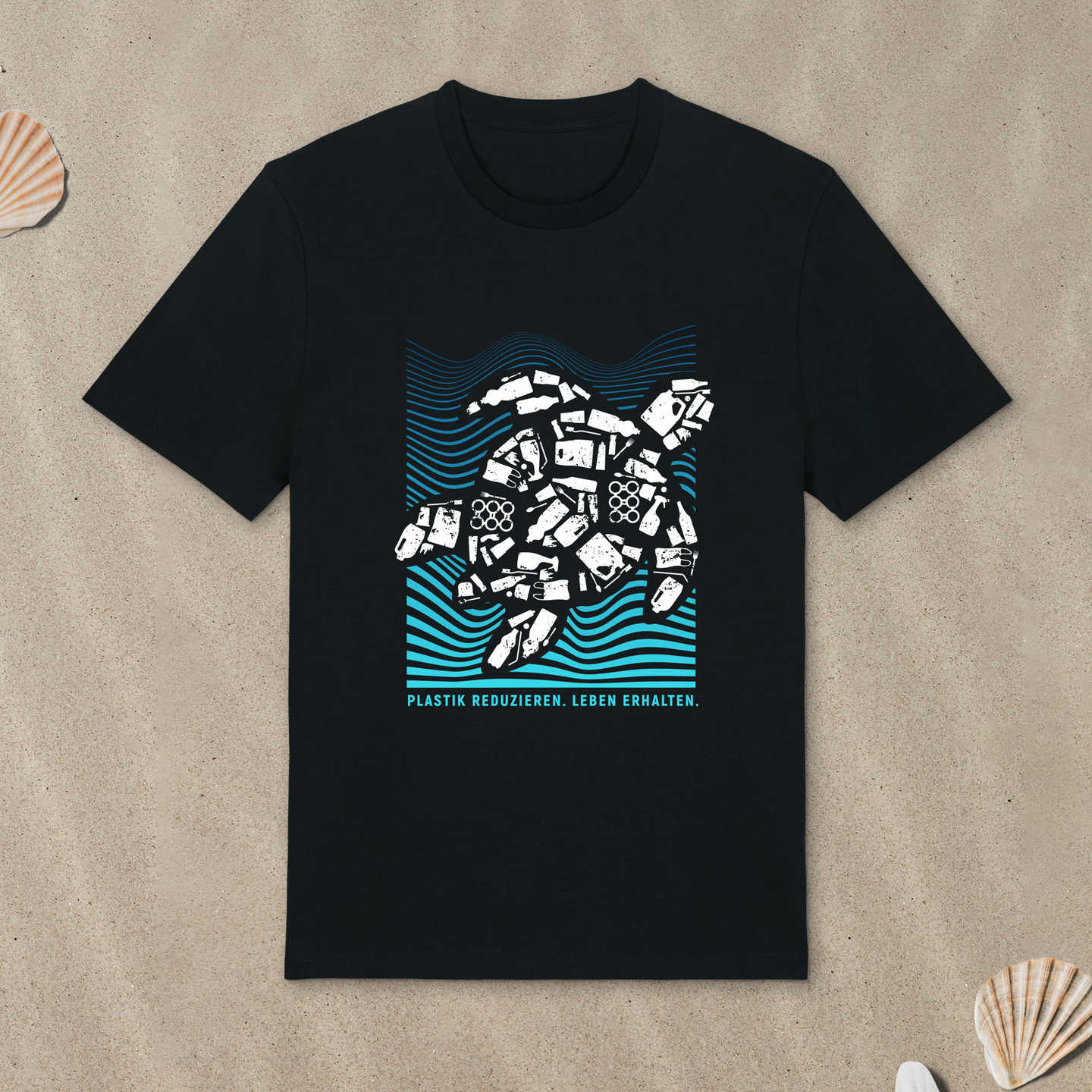 Schwarzes T-Shirt mit Meeresschildkröte-Motiv liegt im Sand.