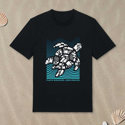 Schwarzes T-Shirt mit Meeresschildkröte-Motiv liegt im Sand.